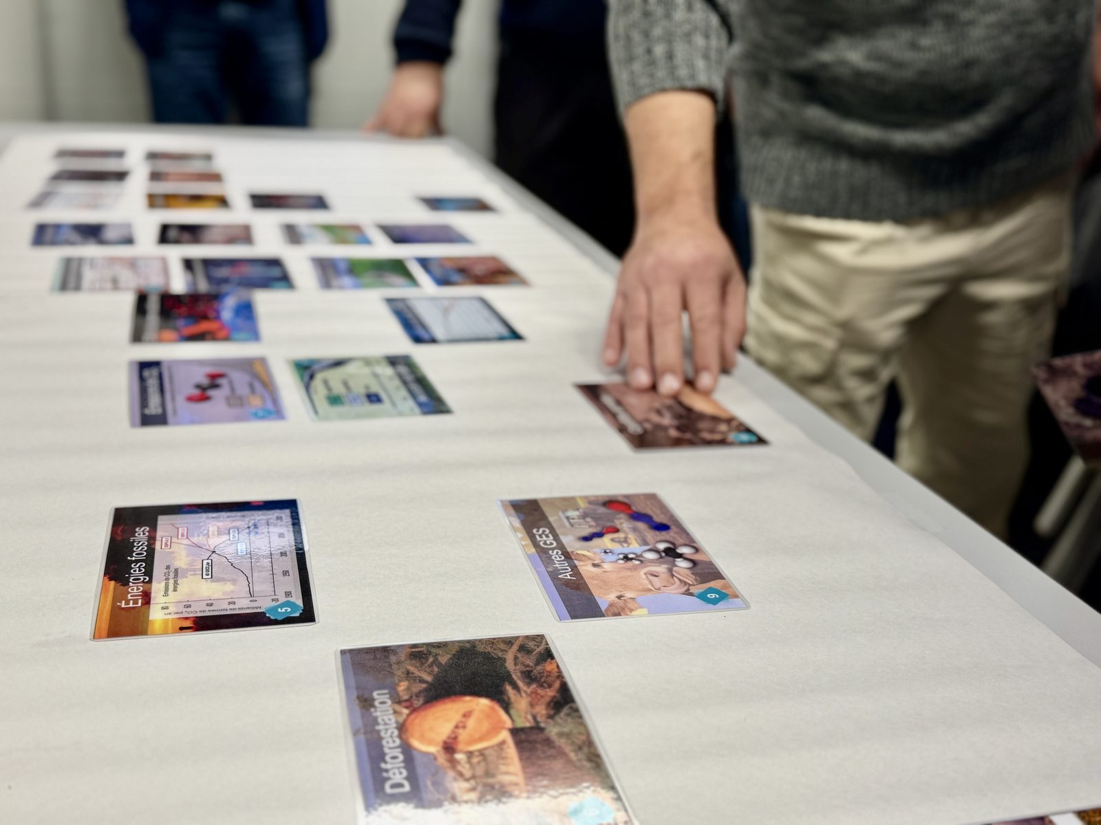 Cartes de la Fresque du Climat disposées sur la table pendant l'atelier : énergies fossiles, déforestation, autres gaz à effet de serre